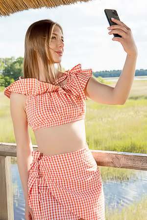 Karianne Bending Over The Railing With A Smile
