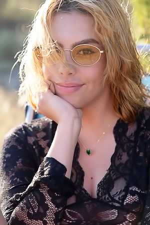 Sally poses nude on a field in the hills